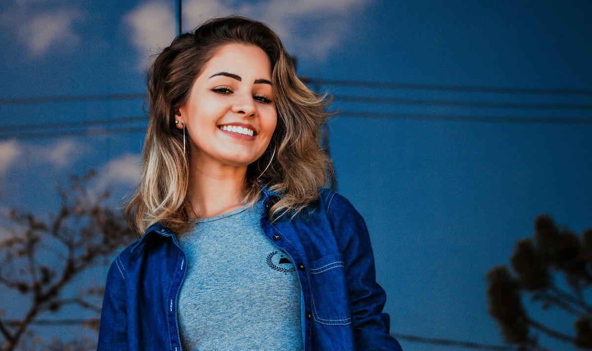 Camisa jeans sobre malha cinza, recorte lido de frente